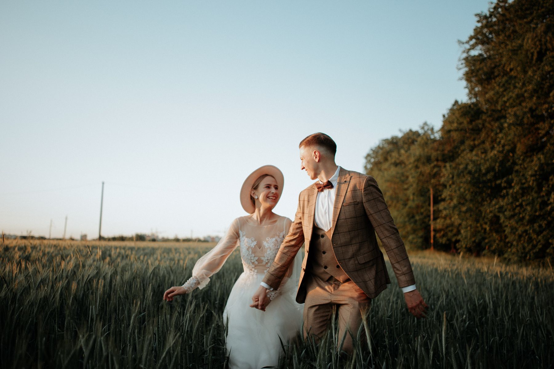 Recién casados caminando juntos por un campo