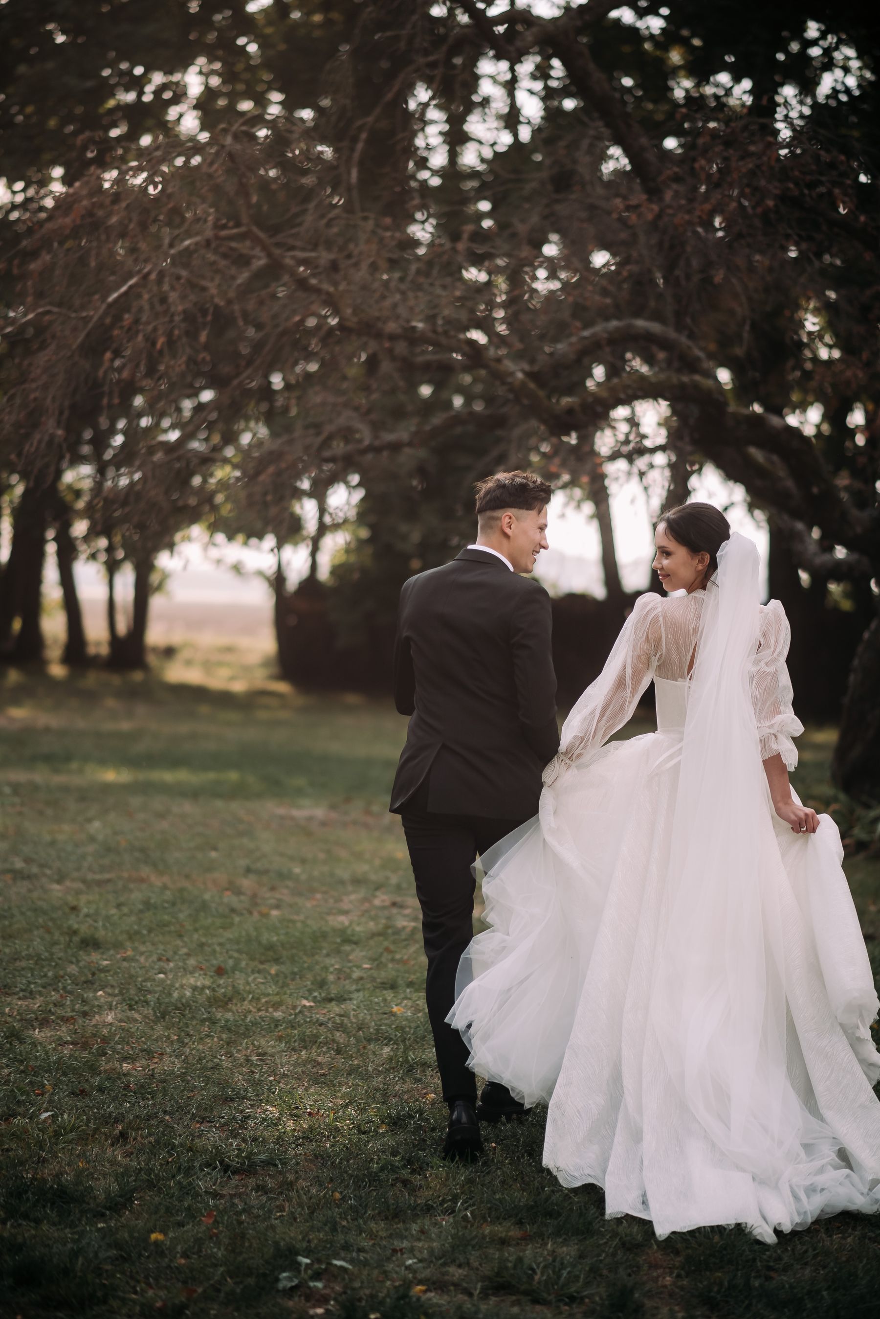 Una pareja de recién casados bajo los árboles